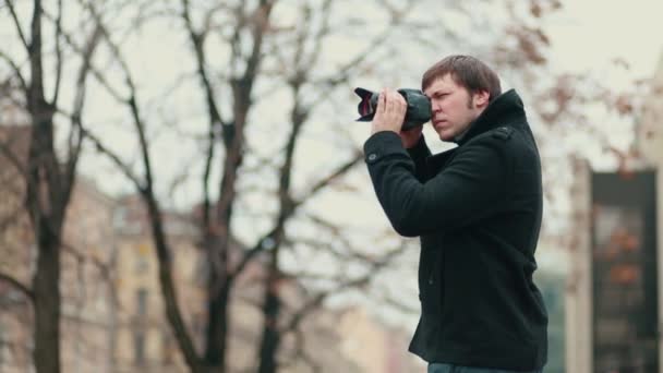 摄影师在寻找美丽的照片 他穿着时髦的外套 狗仔队 — 图库视频影像
