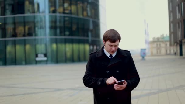 Homme d'affaires répondant au téléphone vêtu d'un manteau noir — Video