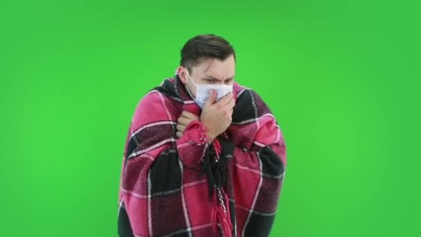 Ein Mann mit Schutzmaske, in ein kariertes Gewand gehüllt, hat eine Hustenerkrankung — Stockvideo