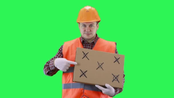 Mężczyzna w hełmie budowlanym i pomarańczowej kamizelce trzyma plakat dla punktów tropiących, zielone tło ekranu — Wideo stockowe