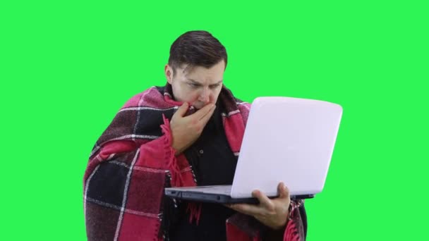 Ein Mann kommuniziert aus der Ferne auf einem Laptop, der seinem Gesprächspartner zeigt, dass er krank ist, grüner Hintergrund — Stockvideo