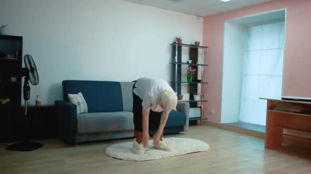 Ältere Frau bei Übungen zu Hause kippt um — Stockvideo