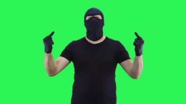 Kar maskeli bir adam iki eliyle orta parmağı, yeşil ekran arka planını gösterir.