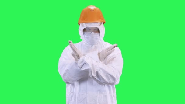 Mann in Helm und Schutzanzug zeigt stop.Green Screen Hintergrund. — Stockvideo