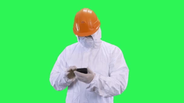 Ein Mann mit Helm und Schutzanzug surft am Telefon.. — Stockvideo