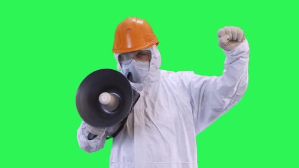 Un hombre en un casco y un traje de protección habla en una caja de gritos haciendo demandas.Fondo de pantalla verde . — Vídeo de stock