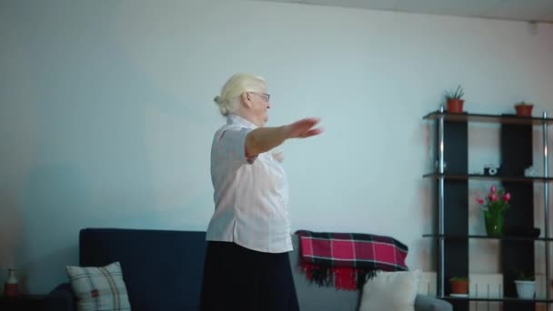 Volwassen vrouw doet oefeningen in haar kamer — Stockvideo