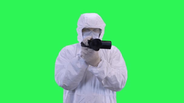 A man in a protective suit and goggles is filming a video camera.Green screen background. — Stock Video