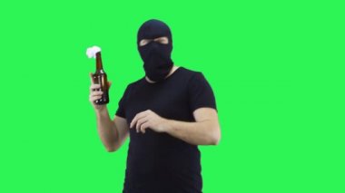 Siyah maskeli bir adam elinde müreffeh bir karışım olan bir şişe tutuyor ve nereye atacağına bakıyor. Kar maskesi. Yeşil ekran arka plan..