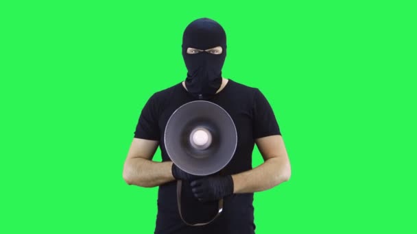 Um homem em uma balaclava, gritando com um grito, fundo de tela verde — Vídeo de Stock