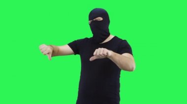 Maskeli bir adam iki eliyle parmaklarını indiriyor. Kar maskesi. Yeşil ekran arka plan..