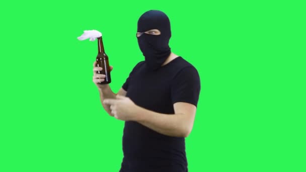 Een man met een zwart masker houdt in zijn hand een fles met een welvarend mengsel, wijst naar de fles.Balaclava.Groen scherm achtergrond. — Stockvideo