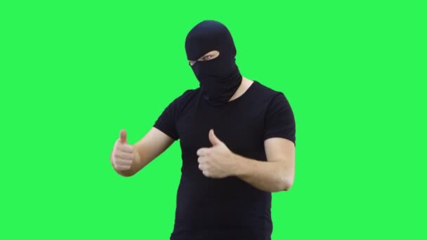Человек в маске с двумя руками показывает большие пальцы вверх. Balaclava.Green фон экрана . — стоковое видео