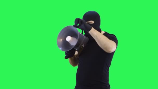 En man i en balaklava talar i rop, grön skärm bakgrund — Stockvideo