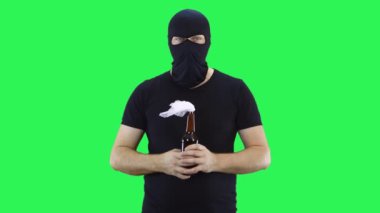 Siyah maskeli bir adam elinde bir şişe molotof kokteyli tutuyor. Kar maskesi. Yeşil ekran arka plan..