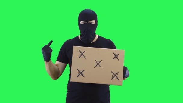Человек в черной маске держит табличку для походов, зеленый фон экрана — стоковое видео