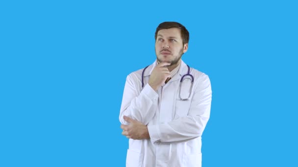पांढरा वैद्यकीय कोटमध्ये एक माणूस विचार करीत आहे आणि काहीतरी विचार करीत आहे . — स्टॉक व्हिडिओ