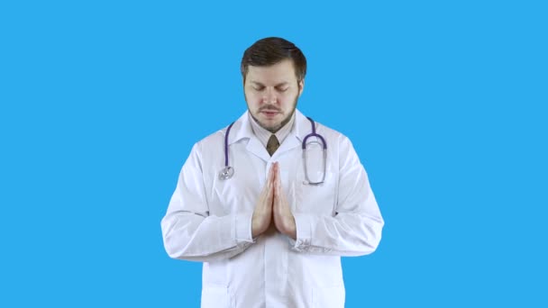 Een man in een witte medische jas bidt en leest een gebed.. — Stockvideo