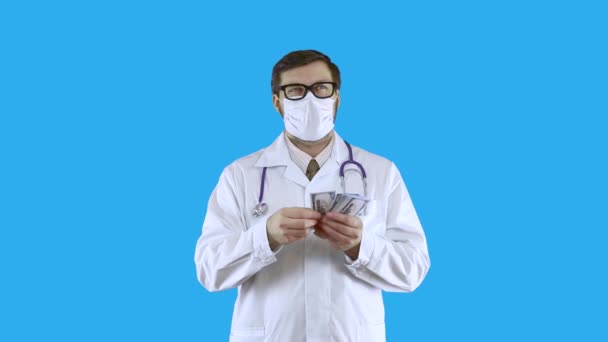 A young man in a white medical coat and mask slowly counts the money and throws it on the floor. — Stock Video