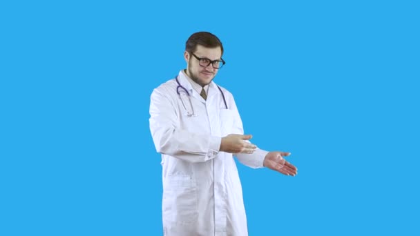 Um homem com um casaco médico branco e óculos mostra para escolher isso . — Vídeo de Stock