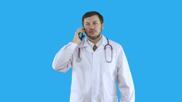 Ein Arzt im weißen Arztkittel telefoniert. — Stockvideo