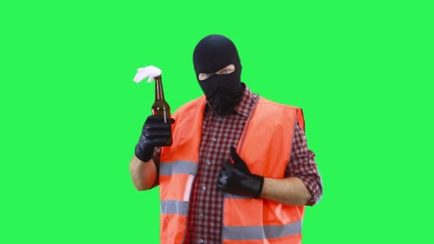 En man i svart mask och en orange väst håller en molotovcocktail i sina händer.. — Stockvideo