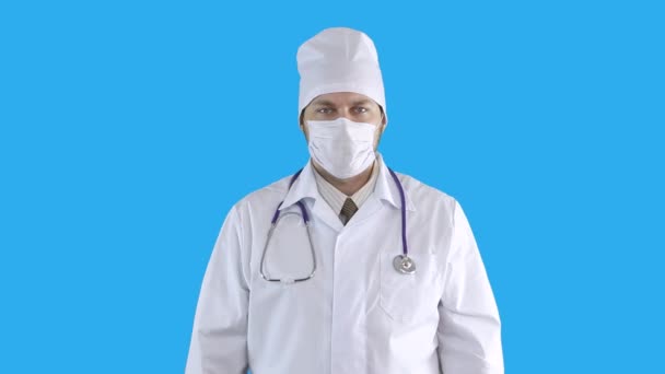 Videoporträt eines Arztes in medizinischem Mantel und Maske. — Stockvideo