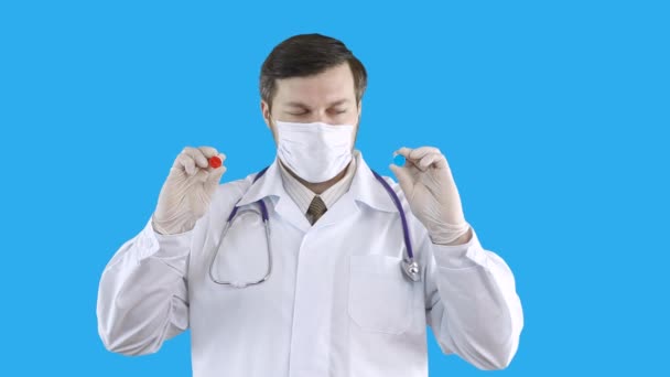 The doctor in a medical coat and mask suggests making a choice of pills. — Stock Video