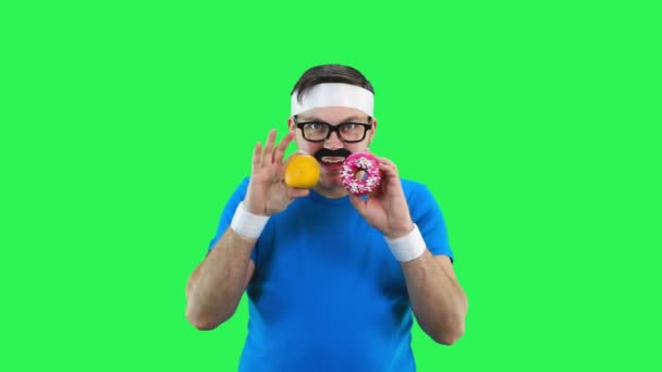 Чоловічий спортсмен робить вибір їсти фрукти або пончик . — стокове відео