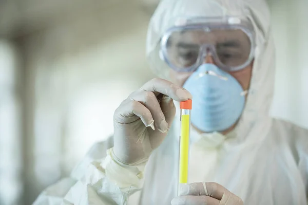 研究室内でコロナウイルスの検査結果を保持する保護具を身に着けている科学者 — ストック写真