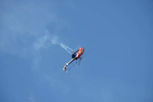 Helicóptero Red Bull Actuando Durante Espectáculo Aéreo Contra Cielo Azul Fotos de stock libres de derechos