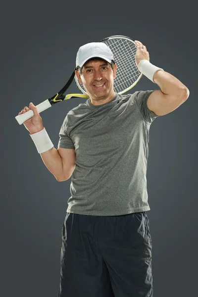 一个成熟的男人 头上顶着网球拍 在灰色的背景下与世隔绝 — 图库照片