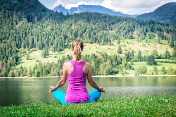 Kobieta, medytując nad jeziorem — Zdjęcie stockowe