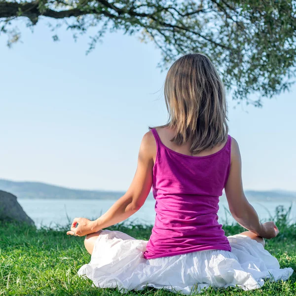 Mulher meditando no lago — Fotografia de Stock