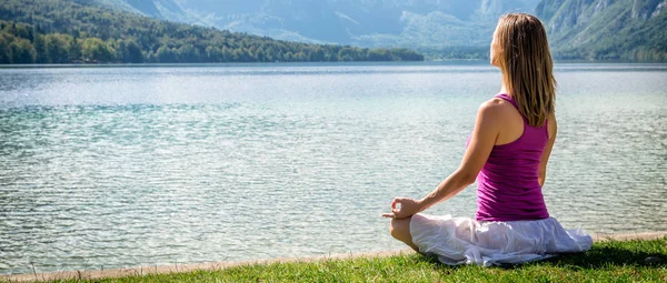 Mulher meditando no lago — Fotografia de Stock