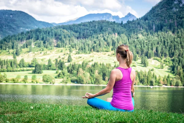 Женщина медитирует на озере — стоковое фото