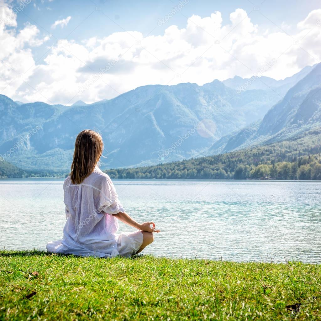 Woman meditating at the lake