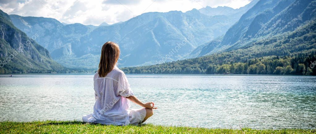 Woman meditating at the lake