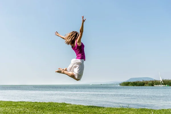 Девушка прыгает по озеру — стоковое фото