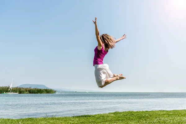 Ragazza che salta sul lago — Foto Stock