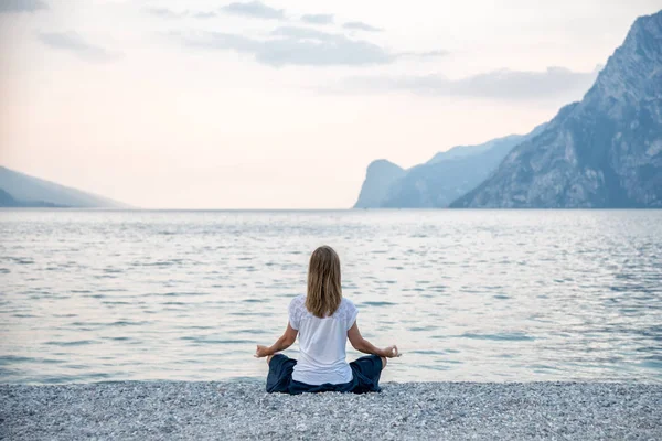 Mujer meditando en el lago —  Fotos de Stock