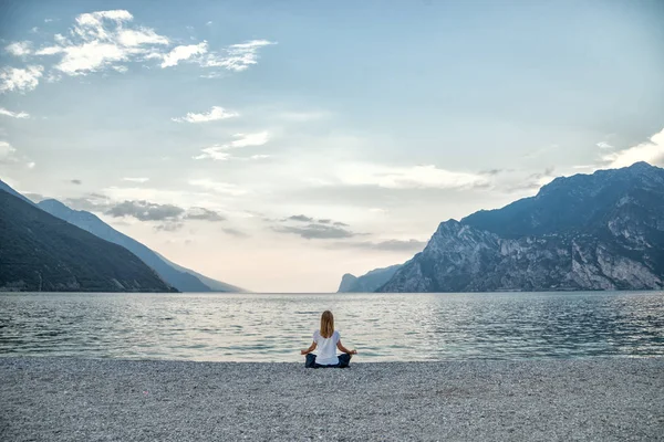 Žena meditace u jezera — Stock fotografie