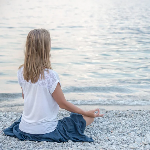 Žena meditace u jezera — Stock fotografie