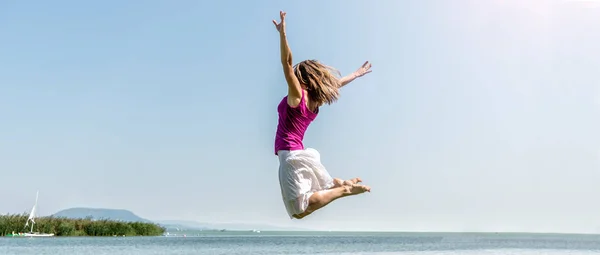 Ragazza che salta sul lago — Foto Stock