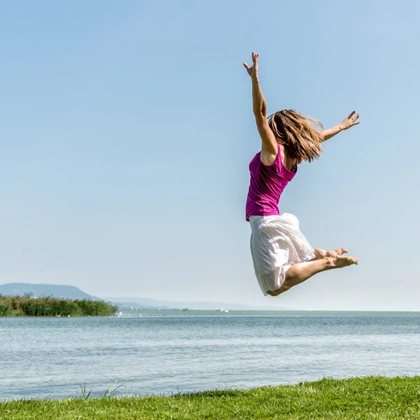 Ragazza che salta sul lago — Foto Stock