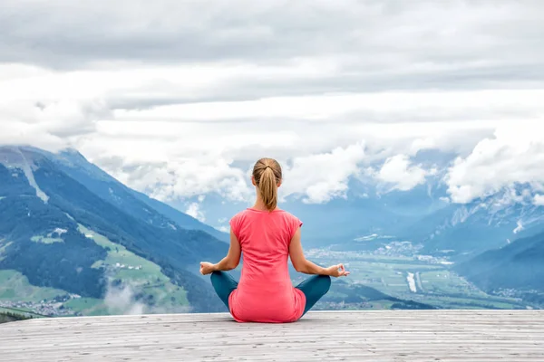 Genç kadın meditasyon dağın zirvesinde — Stok fotoğraf