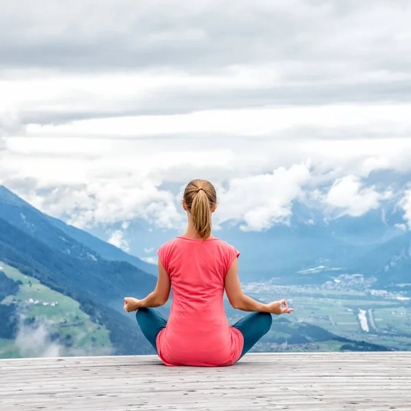 Genç kadın meditasyon dağın zirvesinde — Stok fotoğraf