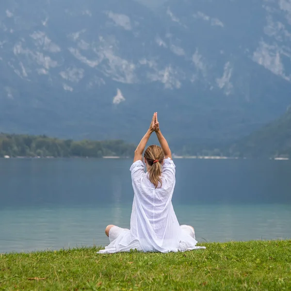 Vrouw mediteren op het meer — Stockfoto