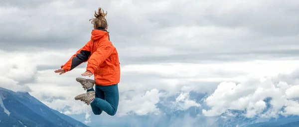 Jonge vrouw op de top van de berg — Stockfoto
