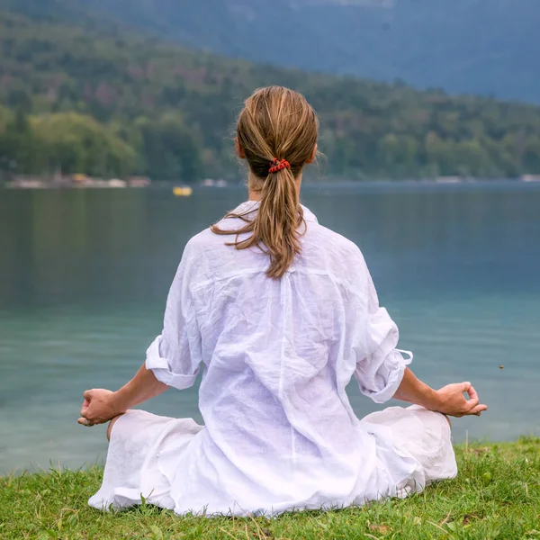 Женщина медитирует на озере — стоковое фото